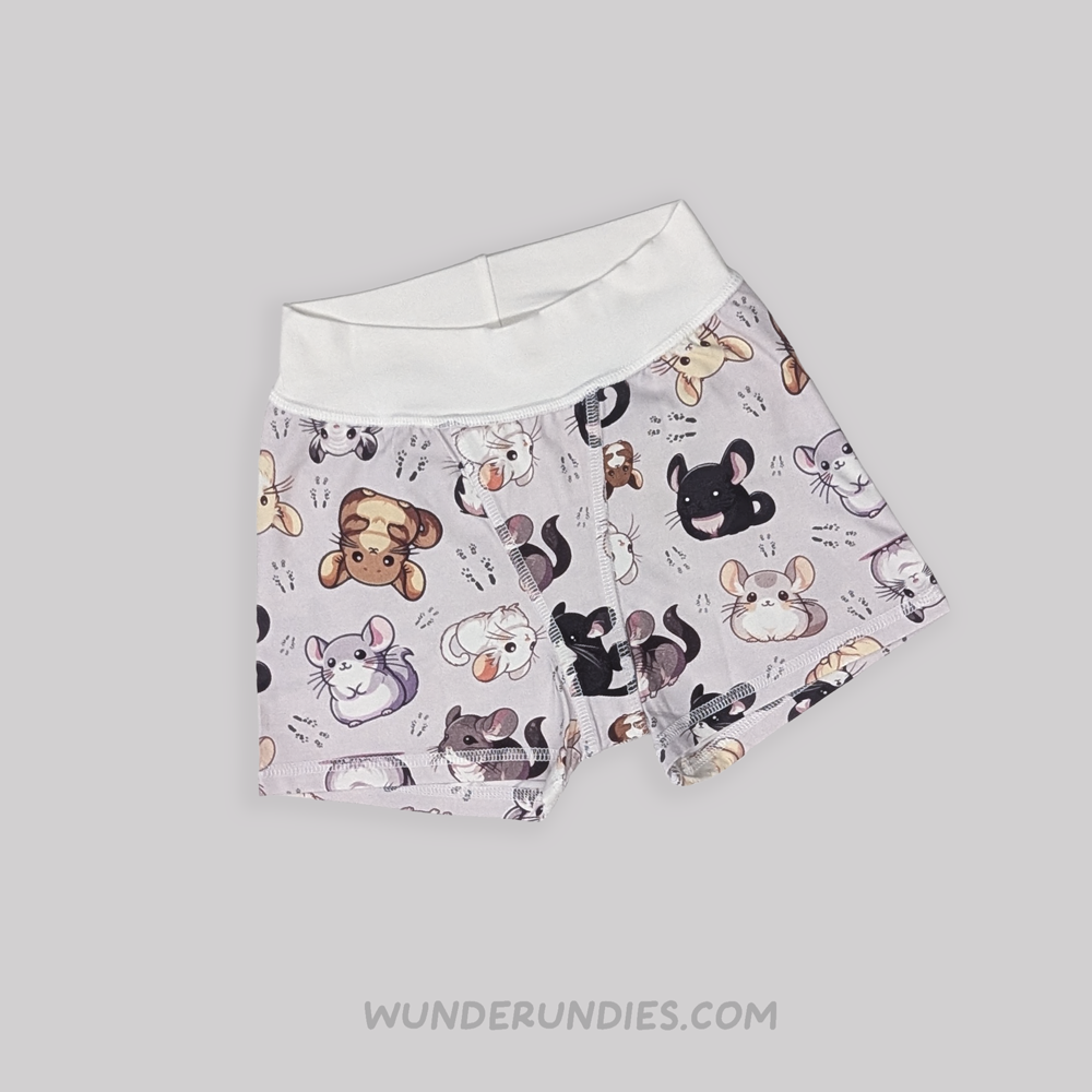 A pair of tagless children's boxer briefs by WunderUndies, featuring a light lavender-gray background with a playful all-over print of chinchillas. The waistband is solid white.