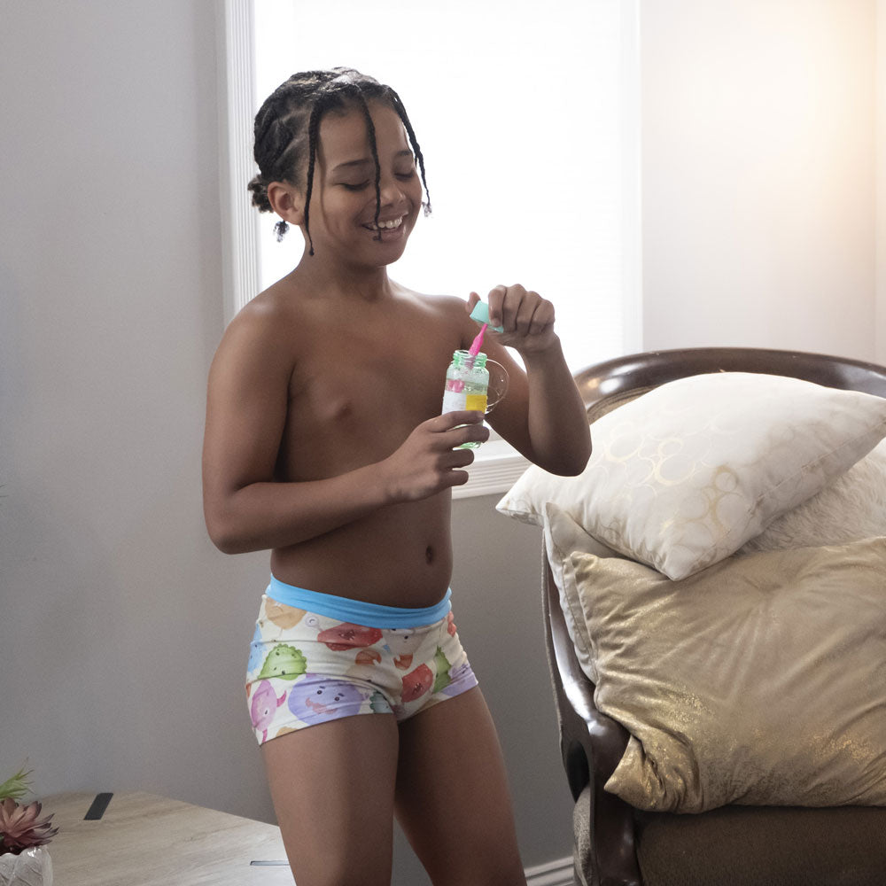 a young boy blowing bubbles in his sensory friendly underwear