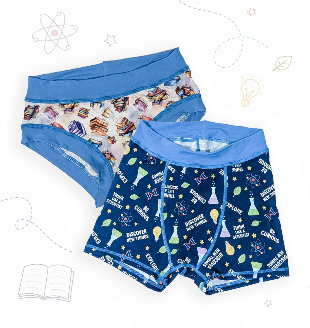 Two pairs of fun, sensory friendly, adult underwear laid flat on a white background with light doodle-style illustrations. The front pair is dark blue with a science-themed print of beakers, test tubes, stars, and the words 'EXPLORE' and 'BE CURIOUS'; the back pair is white with a multicolor pattern of books and illustrations, and has a medium blue waistband.