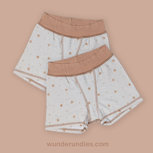 two pairs of sensory friendly children's underwear with star pattern on a beige background, featuring the brand 'wunderundies'.