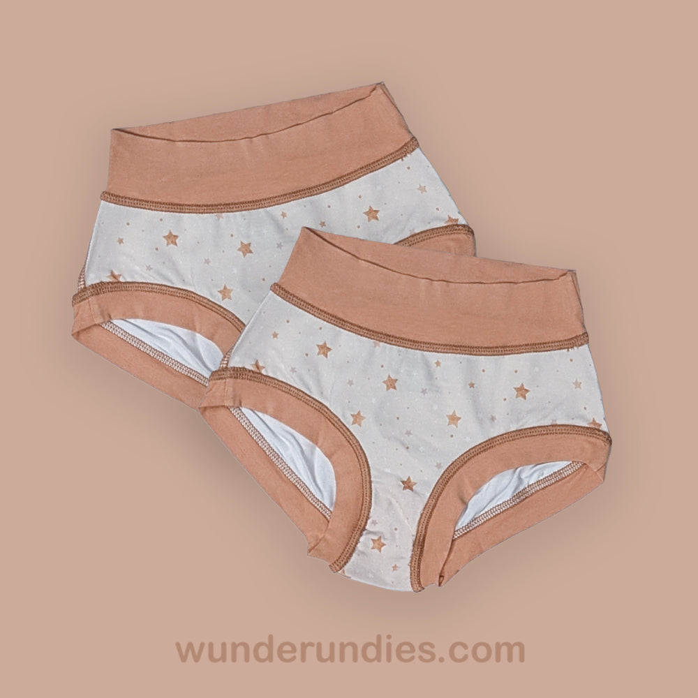 two pairs of kid's sensory friendly underwear with star pattern on a beige background, featuring the brand 'wunderundies.com'.