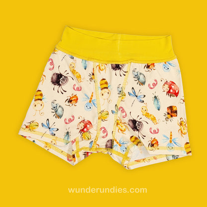 Children's underwear with cute insect pattern on a yellow background, featuring the brand 'wunderundies.com'.