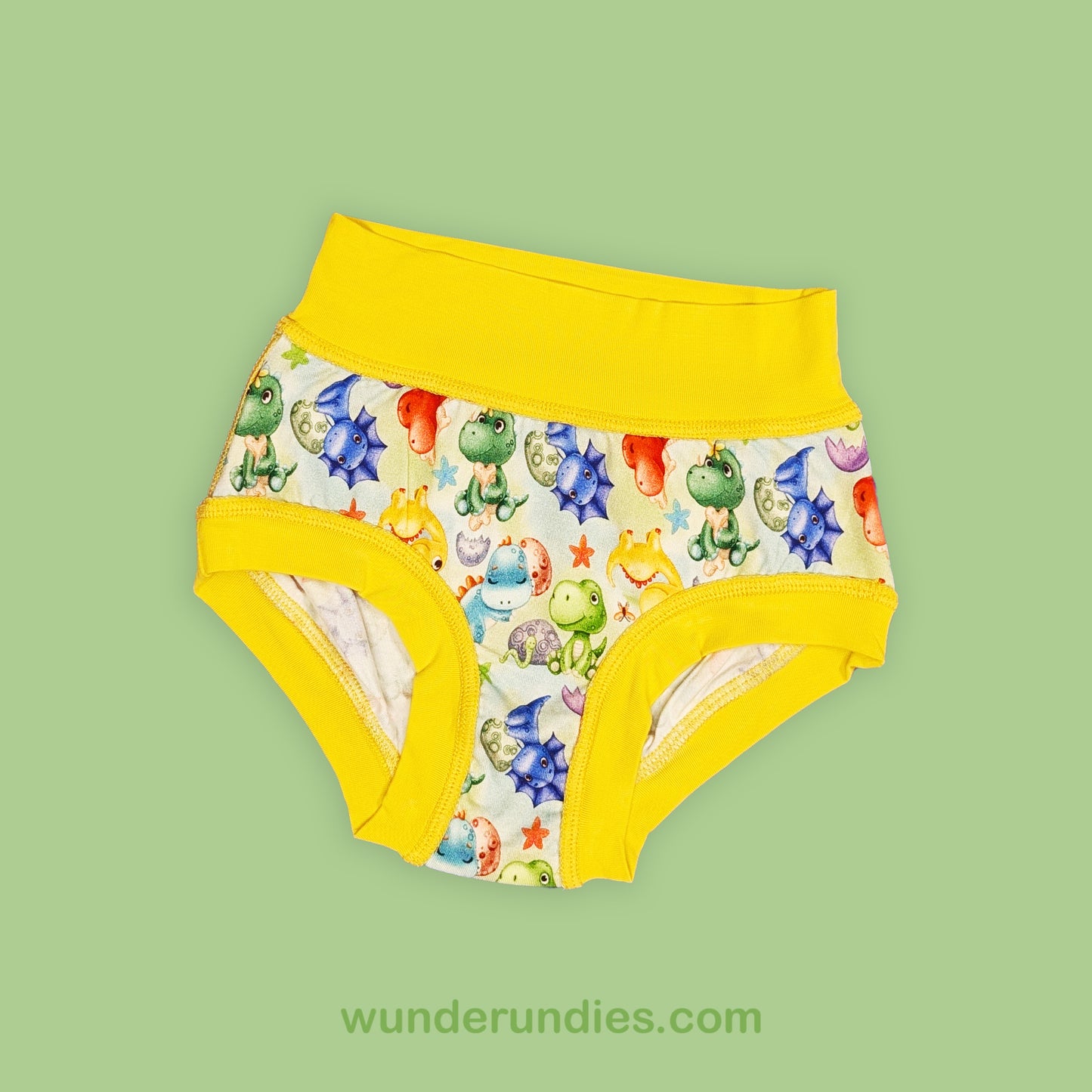 Children's sensory friendly underwear with a dinosaur design and yellow waistband on a green background, featuring the brand 'wunderundies.com'.