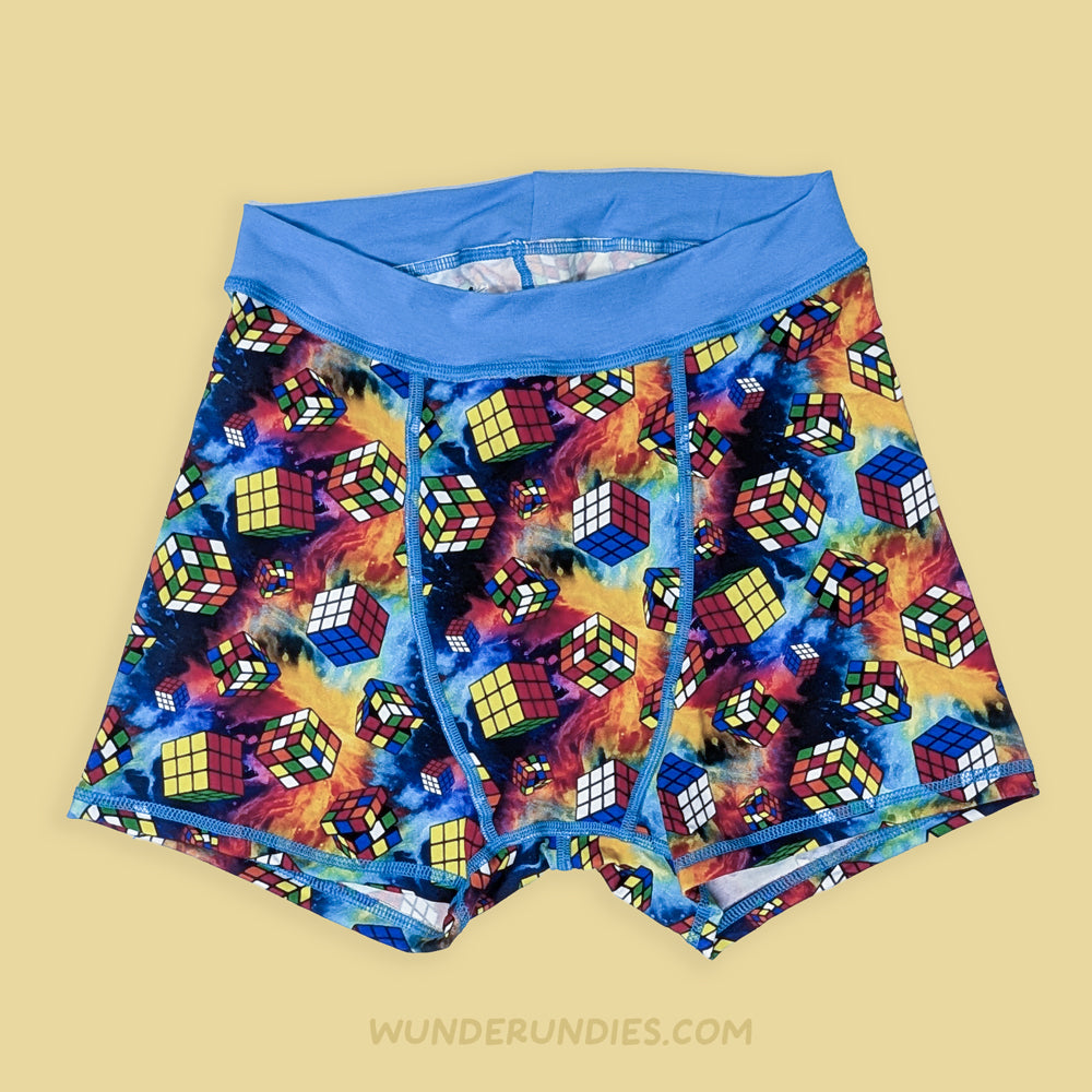 Colorful Rubik's Cube patterned underwear with blue waistband on a beige background, brand 'Wunderundies' visible.