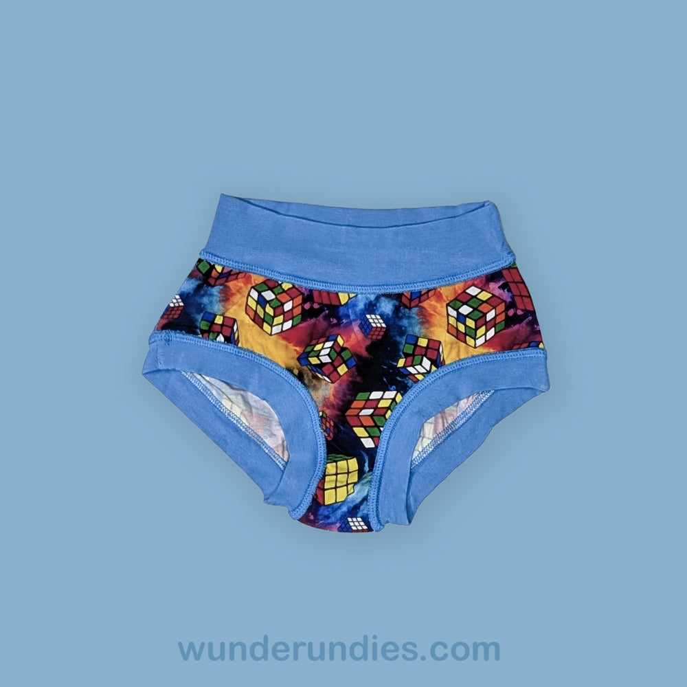 Colorful Rubik's Cube patterned underwear with blue waistband on a light blue background, brand 'wunderundies' visible.