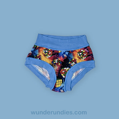 Colorful Rubik's Cube patterned underwear with blue waistband on a light blue background, brand 'wunderundies' visible.