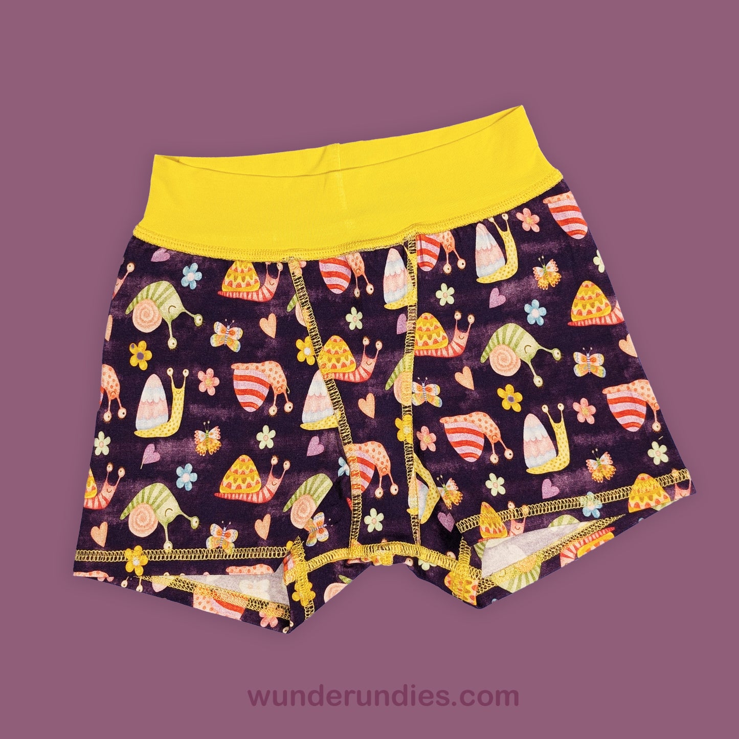 Colorful children's underwear with cartoon snails and flowers on a purple background, branded 'wunderundies'.