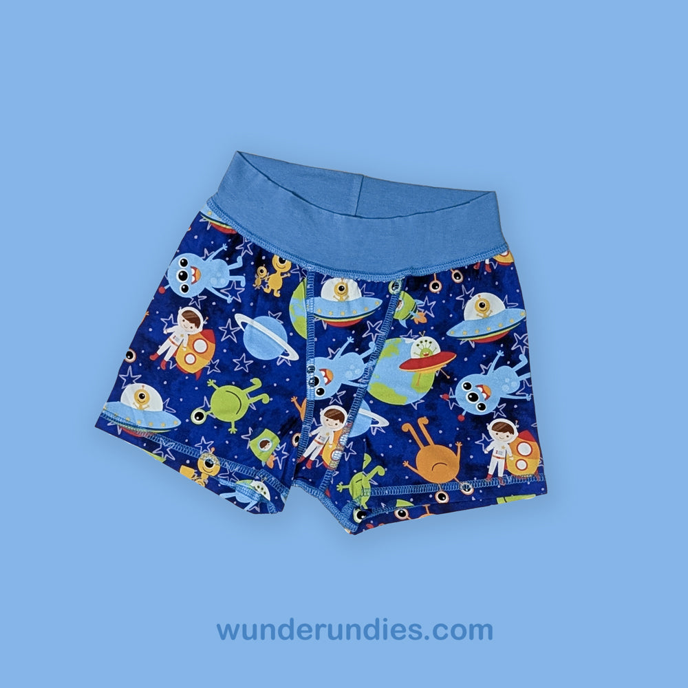 Children's boxer briefs with space-themed design on a blue background, featuring the brand 'wunderundies'.