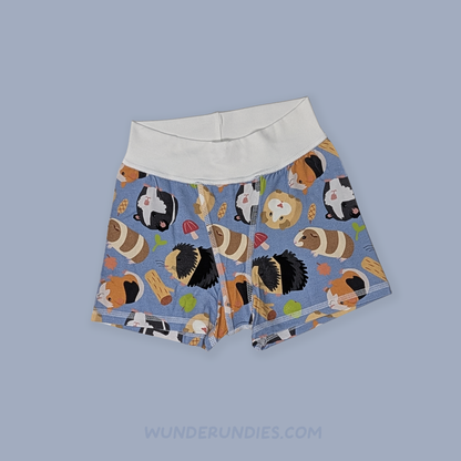 A pair of kids' boxers with a light blue background and a playful pattern of guinea pigs, featuring a solid white waistband. The boxers are displayed flat against a solid light blue-gray background.